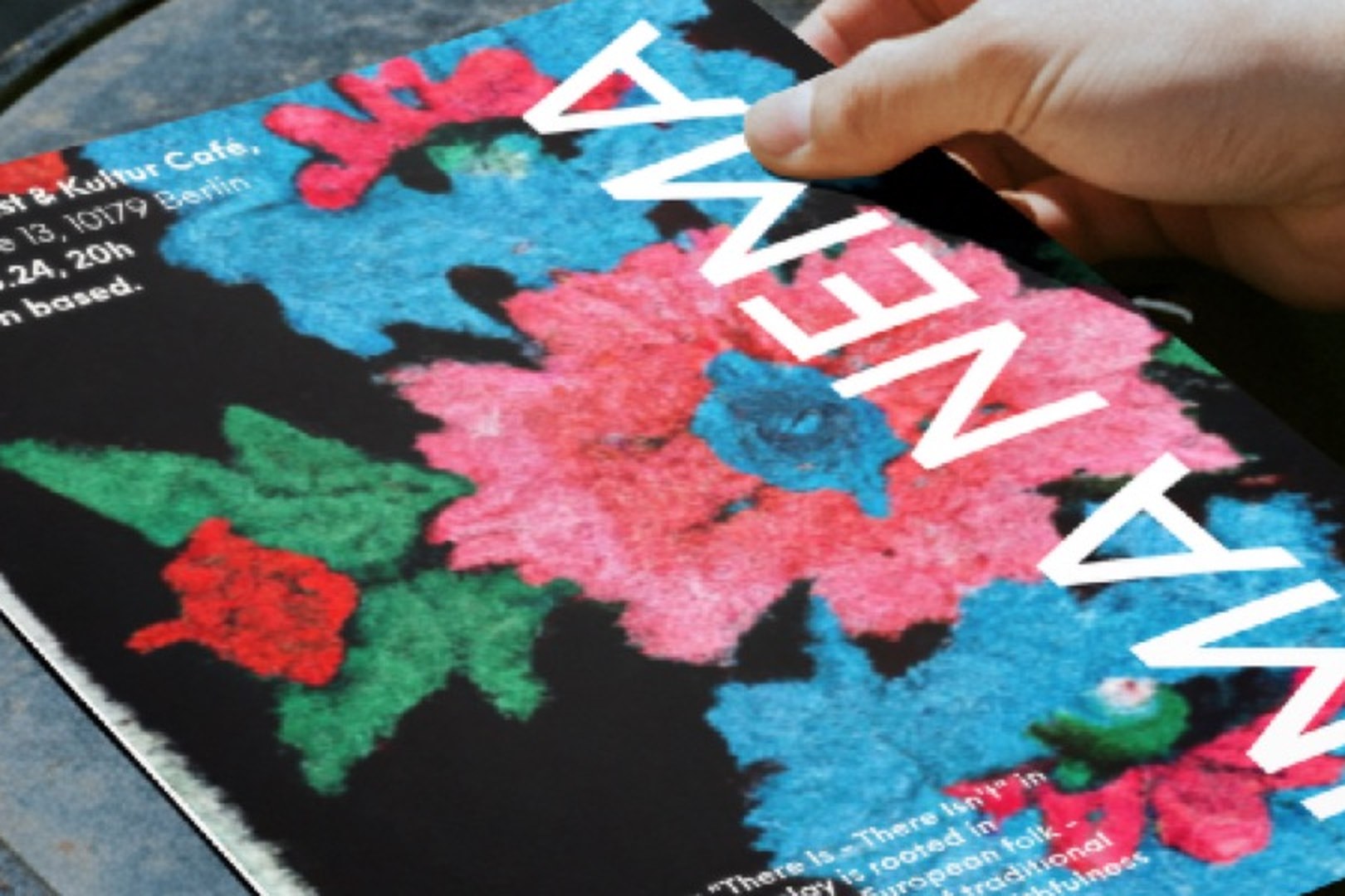 Close-up of the 2024 poster: cross-stitch flowers in pink, blue and green on black