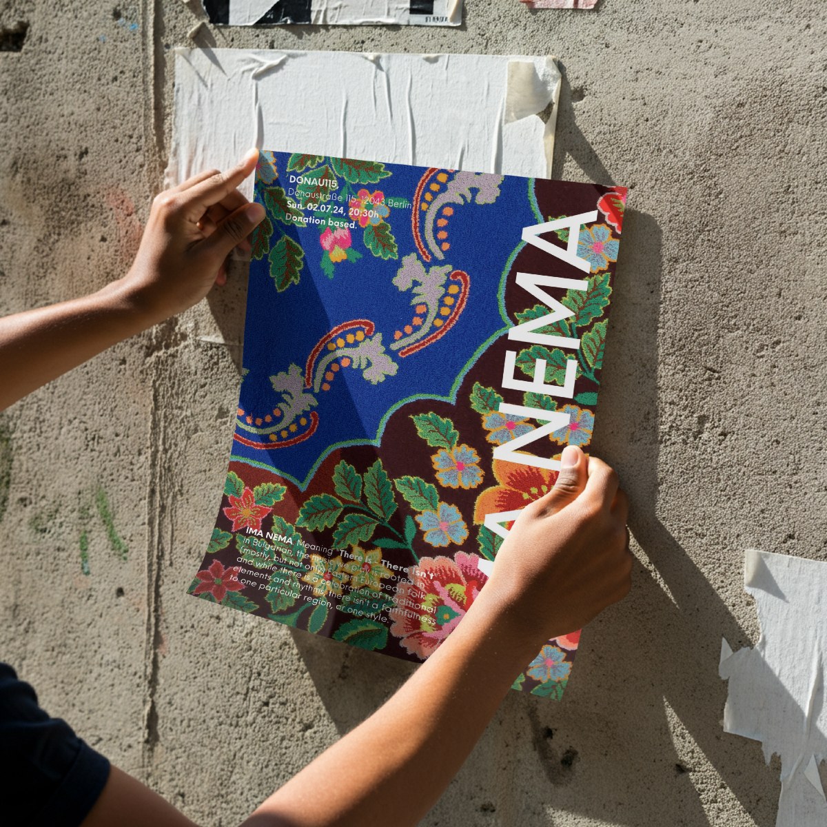 A 2023 IMA NEMA poster being pasted on a concrete wall