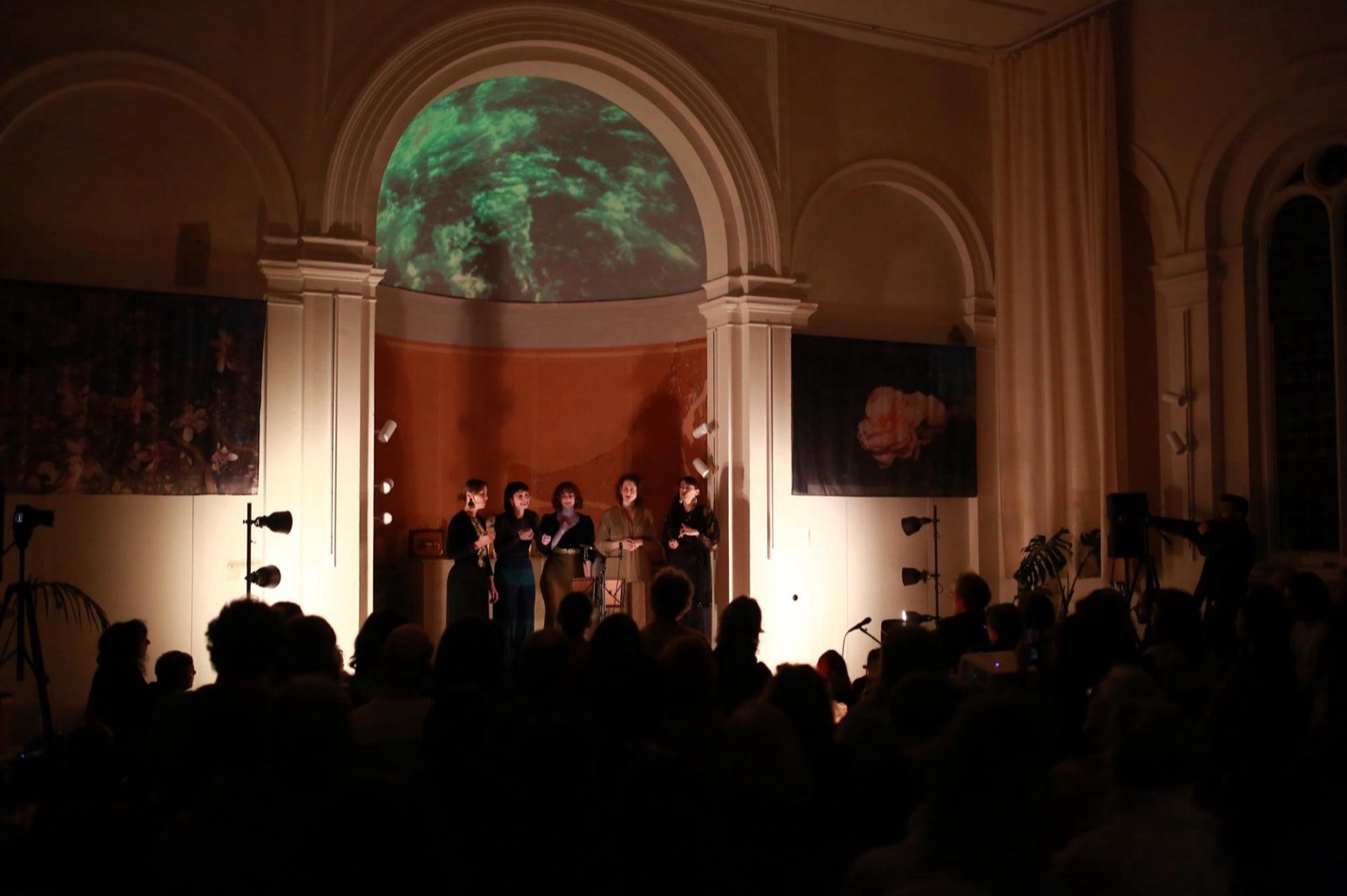 The chapel from the back of the audience: only the half dome of the apse is lit, green