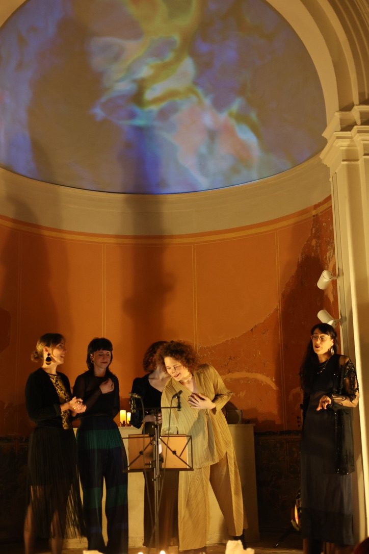 The five singers under the half dome lit in blue and gold
