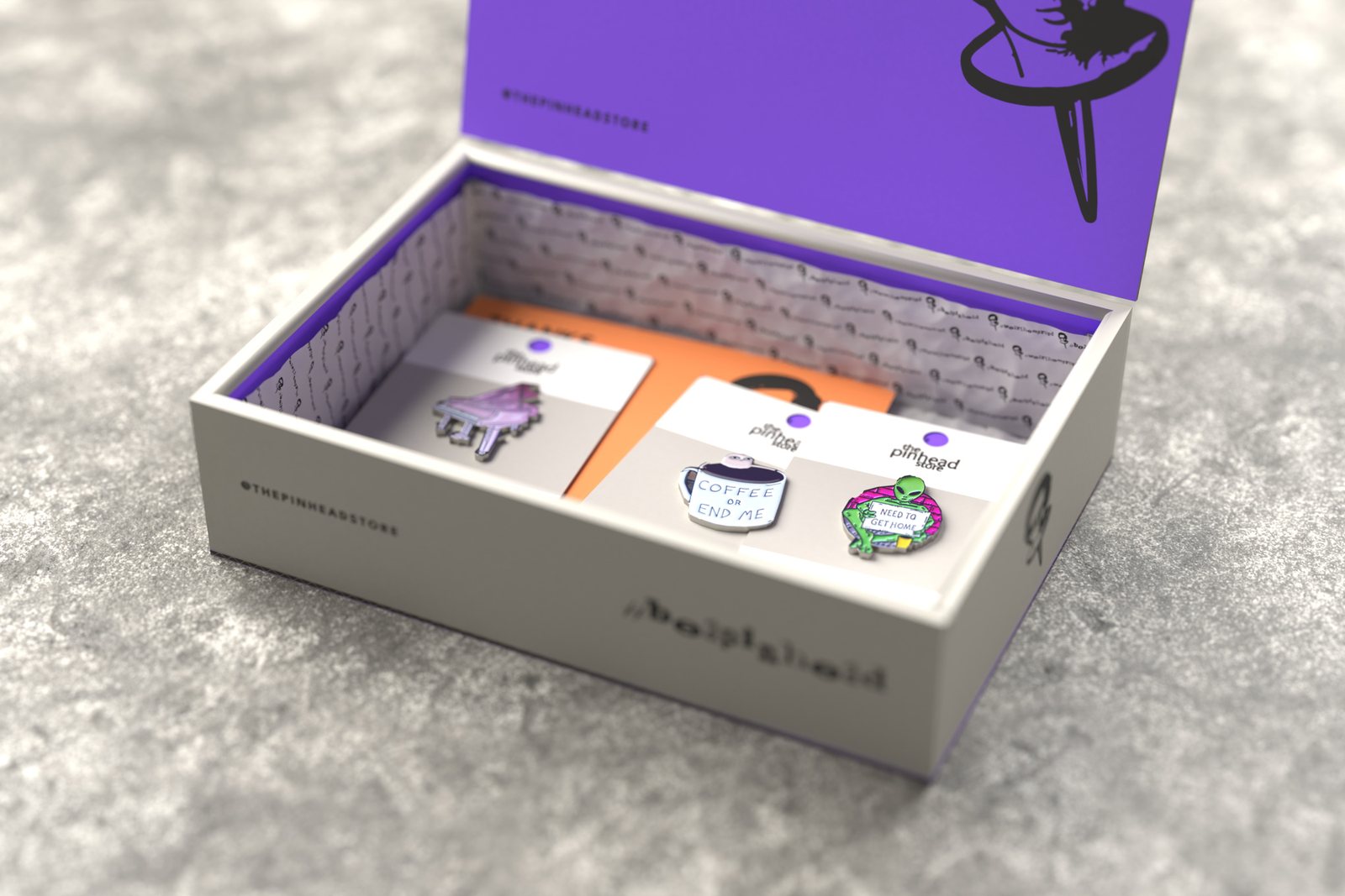 The mailer box open on grey stone: violet inside the lid with Mr. Pin, tissue with the logo, pins on their backing cards