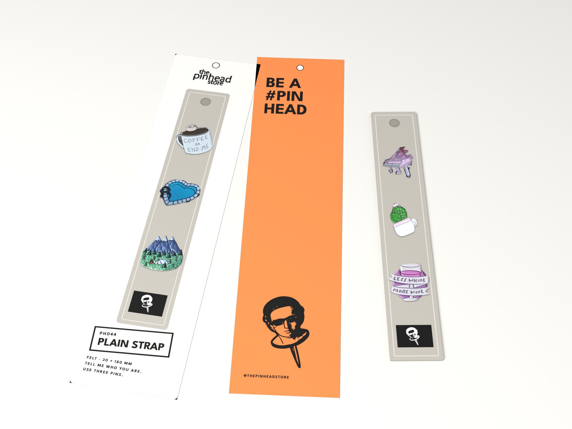 The plain strap: a grey felt strap on a long card, three pins on it, beside the orange back Be a #pinhead