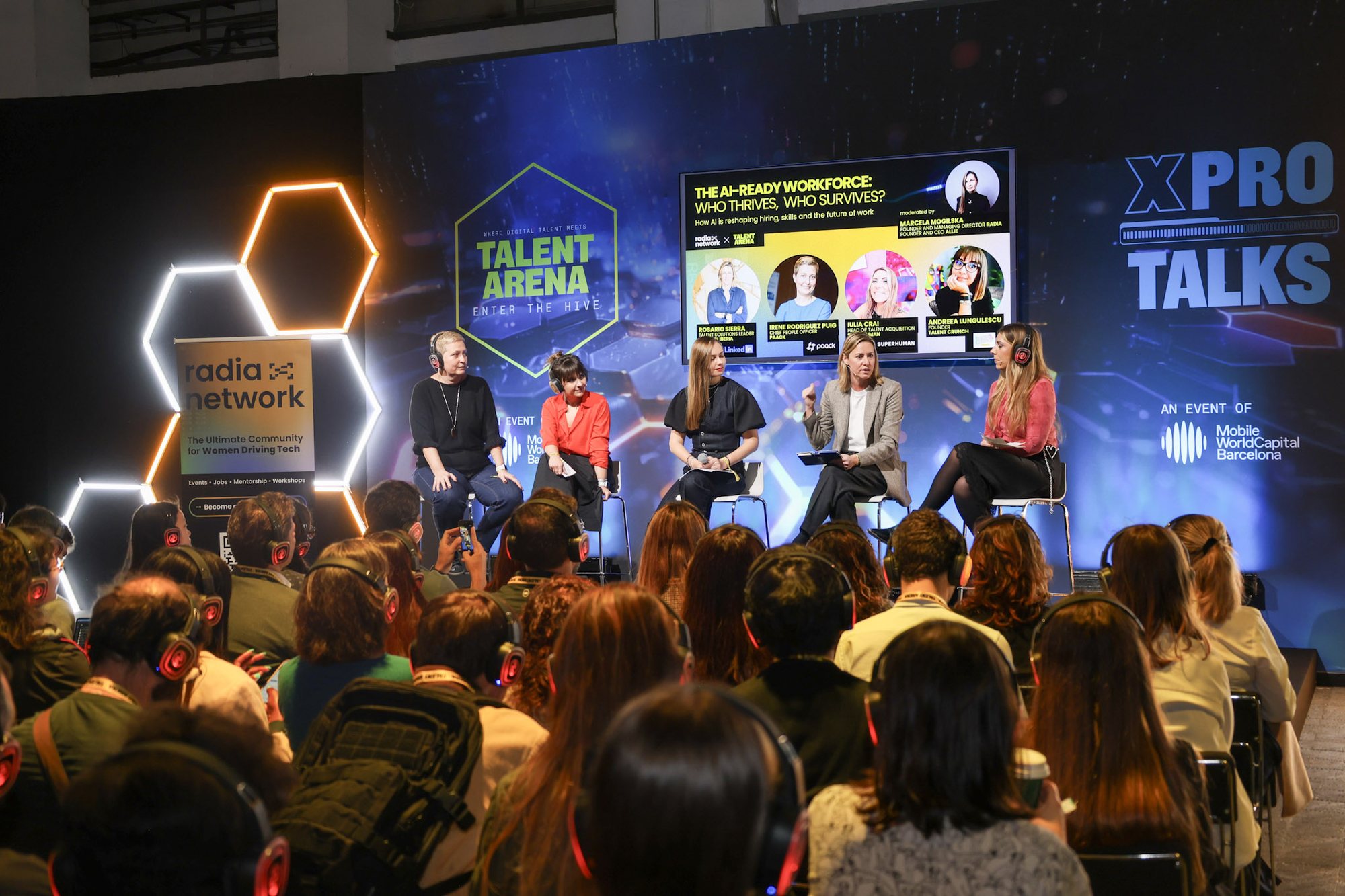 Talent Arena, Barcelona, 3 March 2026: the panel on the stage, the panel slide on the screen above them, the radia network roll-up at the side, the audience in headphones